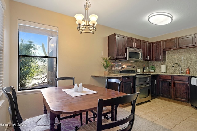 kitchen featuring dark brown cabinets, pendant lighting, stainless steel appliances, light stone countertops, and decorative backsplash