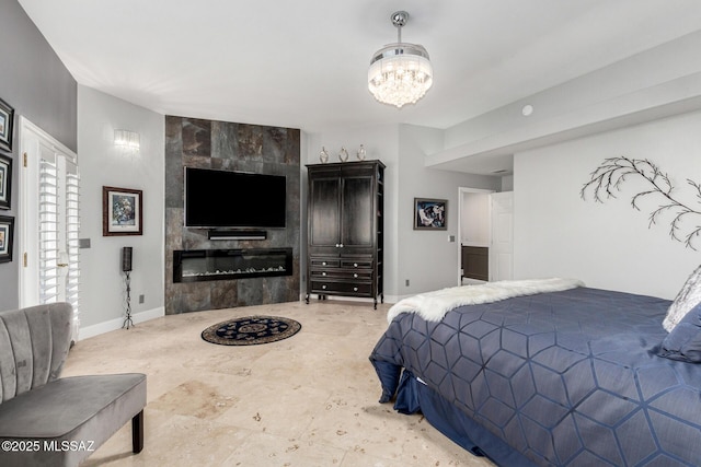 bedroom featuring a tiled fireplace and a chandelier