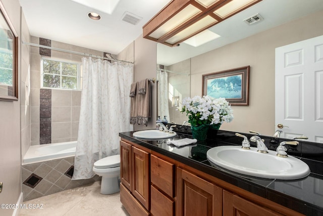 full bathroom featuring a skylight, vanity, toilet, shower / bath combo, and tile patterned floors