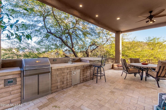 view of patio featuring area for grilling, sink, and ceiling fan