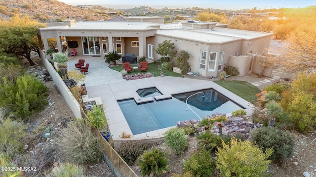 rear view of property featuring a fenced in pool and a patio area