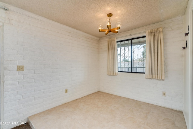 unfurnished room featuring a notable chandelier, a textured ceiling, and brick wall