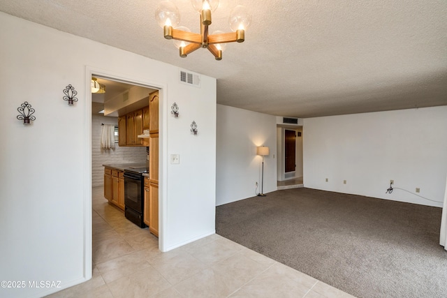 unfurnished living room with light carpet, a textured ceiling, and a chandelier