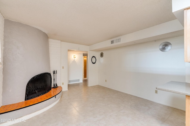 unfurnished living room with a fireplace and a textured ceiling