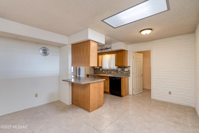 kitchen with tasteful backsplash, a skylight, a textured ceiling, kitchen peninsula, and dishwasher