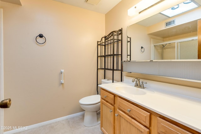 bathroom featuring vanity, toilet, a shower with shower door, and tile patterned flooring