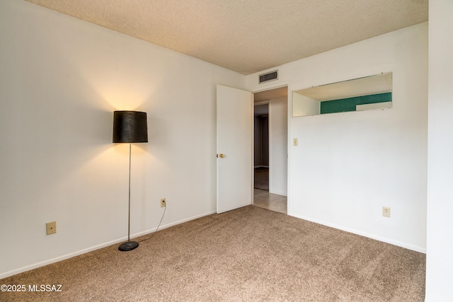 carpeted spare room with a textured ceiling