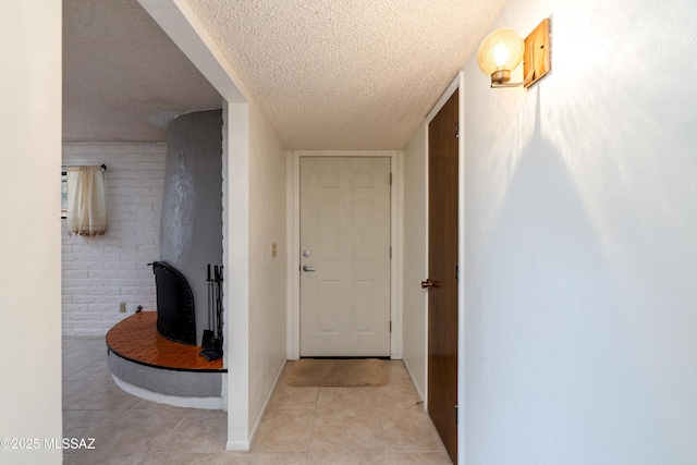 hallway featuring a textured ceiling and light tile patterned floors