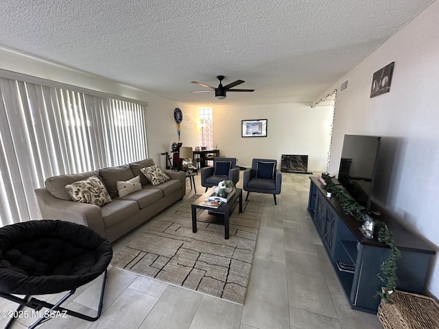 living room with a textured ceiling and ceiling fan