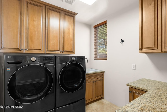 clothes washing area with cabinets, light tile patterned flooring, separate washer and dryer, and sink