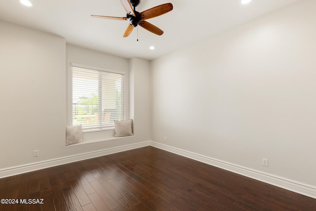 spare room with dark hardwood / wood-style floors and ceiling fan