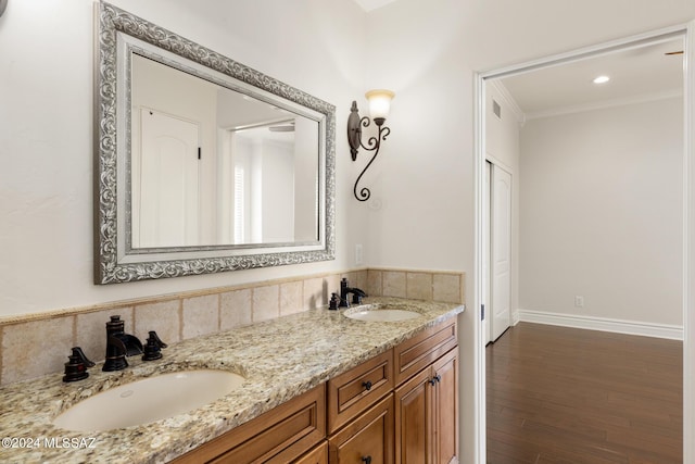 bathroom featuring vanity, wood-type flooring, and ornamental molding