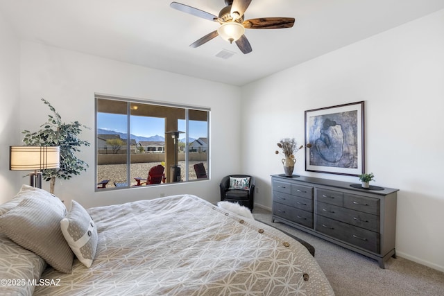 carpeted bedroom with a mountain view and ceiling fan