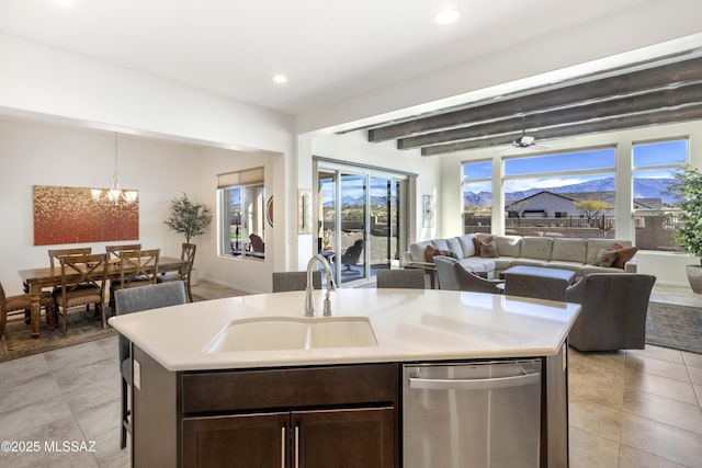 kitchen featuring stainless steel dishwasher, a mountain view, sink, and a center island with sink