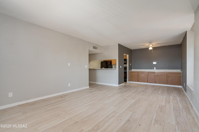 unfurnished living room with ceiling fan and light wood-type flooring