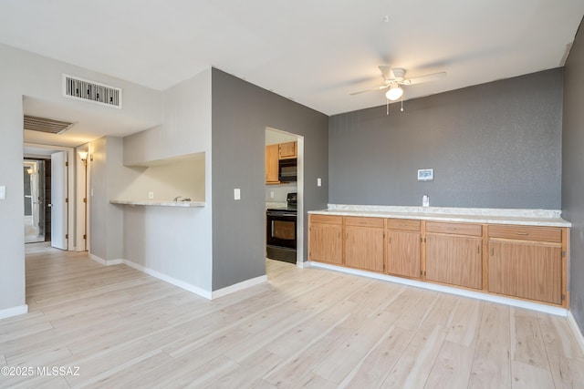 kitchen with ceiling fan, light brown cabinetry, light wood-type flooring, and black appliances