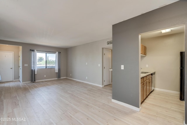 unfurnished living room with sink and light hardwood / wood-style flooring