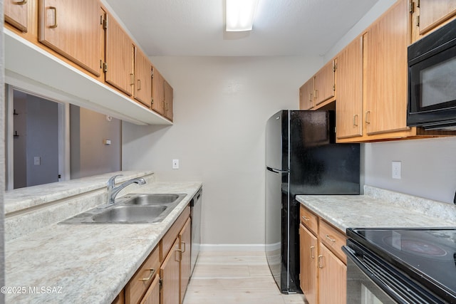 kitchen with light hardwood / wood-style floors, sink, and black appliances