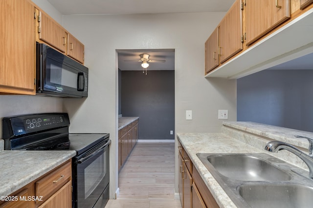 kitchen featuring sink, black appliances, ceiling fan, and light wood-type flooring