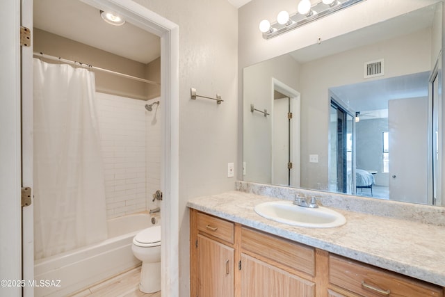 full bathroom featuring vanity, shower / bath combo with shower curtain, and toilet