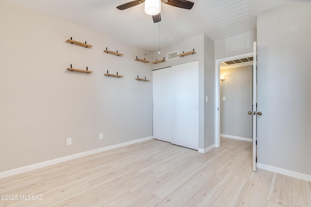 unfurnished bedroom featuring ceiling fan, light hardwood / wood-style floors, and a closet