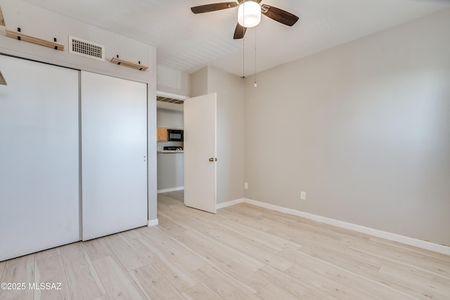 unfurnished bedroom featuring ceiling fan, light hardwood / wood-style floors, and a closet