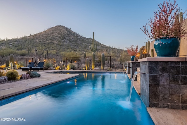 view of pool with pool water feature, a mountain view, and a patio area