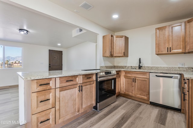 kitchen featuring appliances with stainless steel finishes, kitchen peninsula, sink, and light wood-type flooring