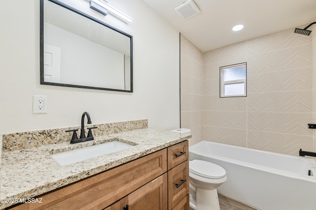 full bathroom with vanity, tiled shower / bath, hardwood / wood-style floors, and toilet