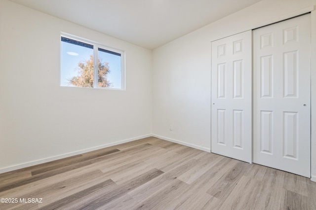 unfurnished bedroom with a closet and light hardwood / wood-style flooring