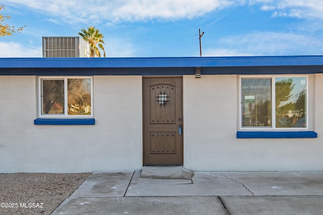 view of exterior entry with a patio