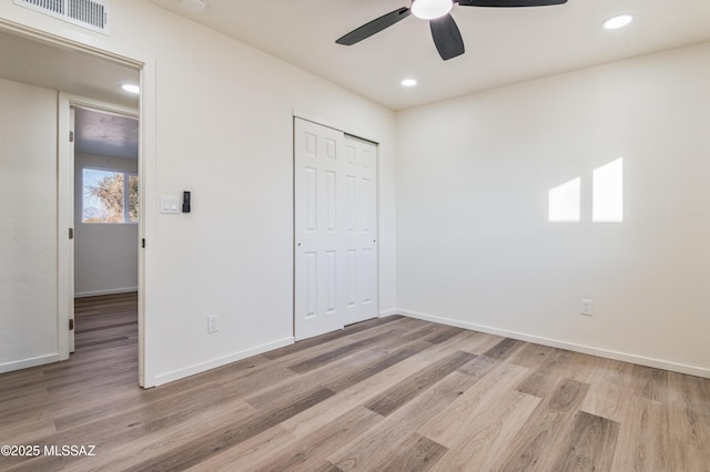 unfurnished bedroom with ceiling fan, light hardwood / wood-style floors, and a closet