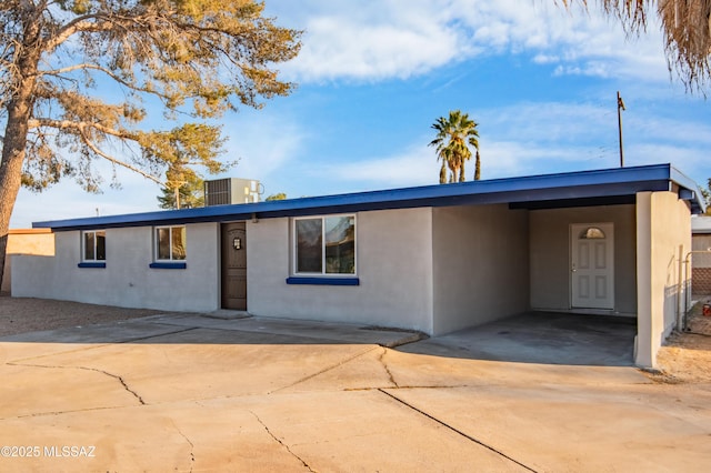 view of front of house featuring a carport and central AC unit