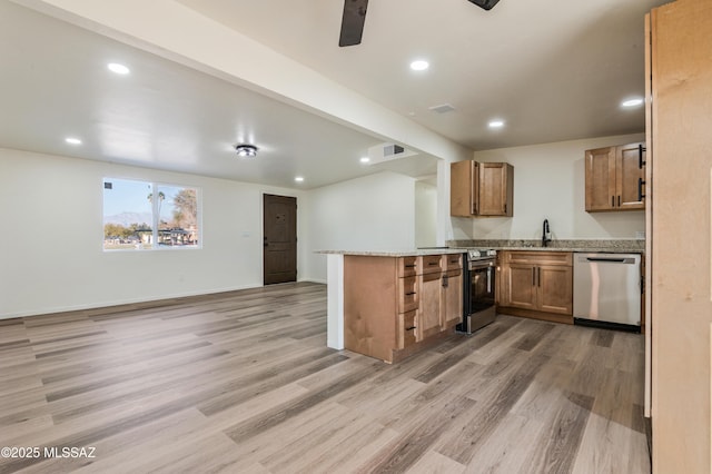 kitchen featuring light stone counters, stainless steel appliances, kitchen peninsula, and light hardwood / wood-style flooring