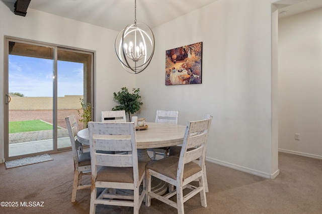 dining room featuring baseboards, a chandelier, and light colored carpet