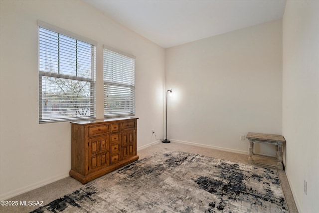 spare room with light colored carpet and baseboards