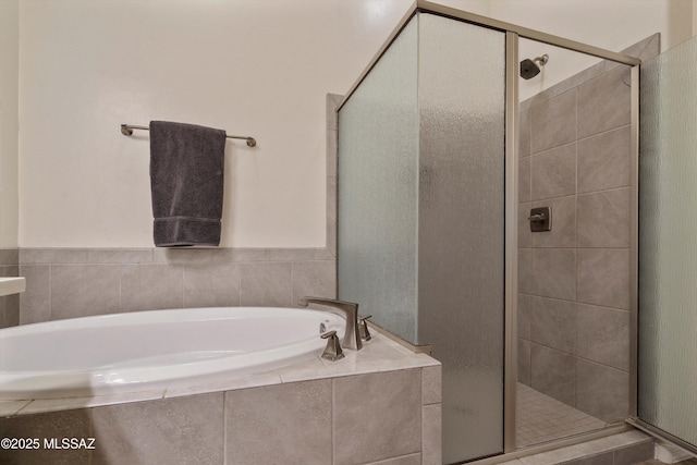 bathroom featuring independent shower and bath