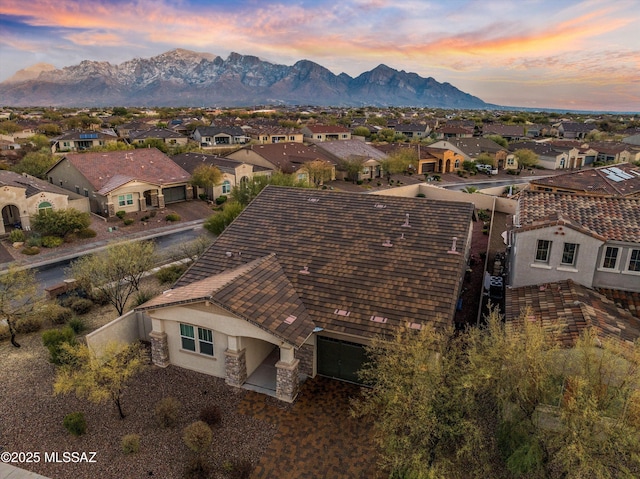 aerial view at dusk featuring a mountain view