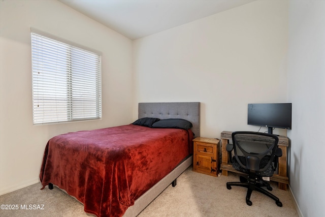 bedroom with baseboards and light colored carpet