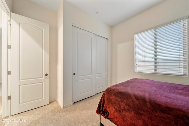 bedroom with a closet and light colored carpet