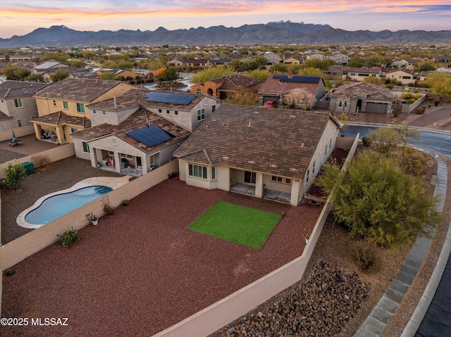 aerial view at dusk featuring a residential view and a mountain view