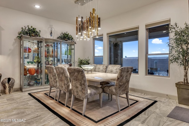 dining area featuring baseboards, marble finish floor, and a notable chandelier