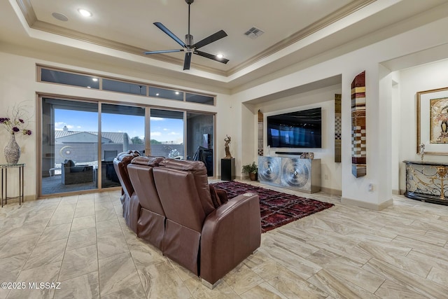 living area with ornamental molding, a tray ceiling, and visible vents