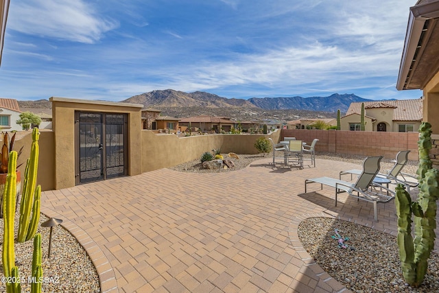 view of patio with french doors, a fenced backyard, and a mountain view