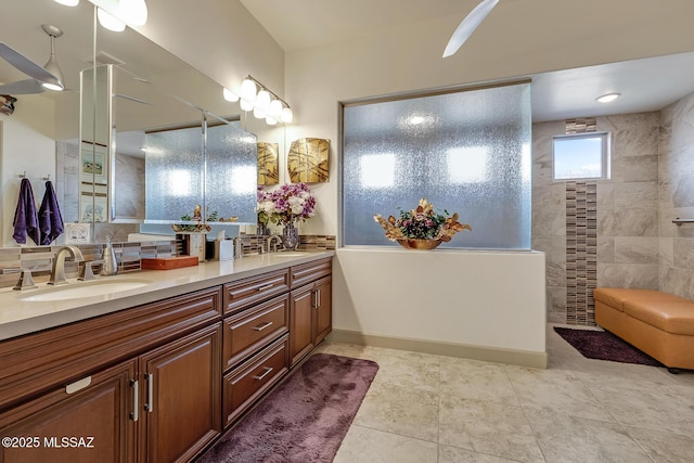 bathroom featuring tile patterned flooring, walk in shower, a sink, and double vanity