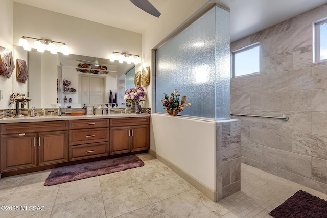 bathroom with double vanity, baseboards, walk in shower, and a sink