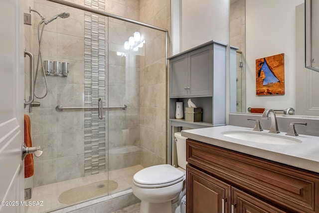 bathroom with toilet, a stall shower, and vanity