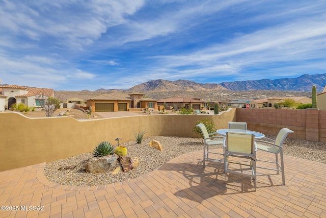 view of patio with fence private yard, outdoor dining area, a residential view, and a mountain view