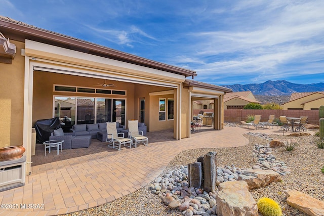 back of property featuring a patio area, fence, a mountain view, and stucco siding