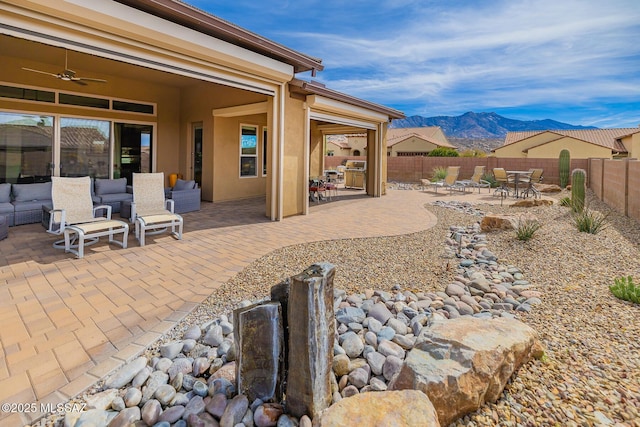 view of patio / terrace with outdoor lounge area, a fenced backyard, a mountain view, and ceiling fan